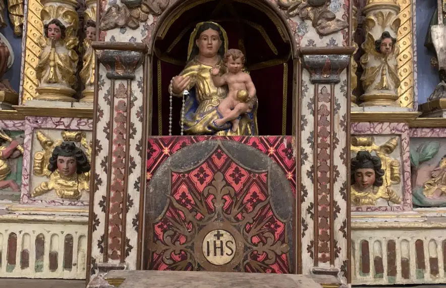 La fornícula central del retaule, avui amb una imatge de la Mare de Déu del Roser, servia per guardar la custòdia i constava d’un mecanisme per obrir la porta.