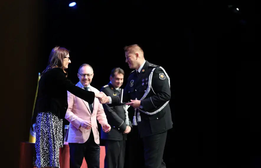 La ministra de Justícia i Interior, Ester Molné, lliura una medalla a un dels agents pels anys de servei.
