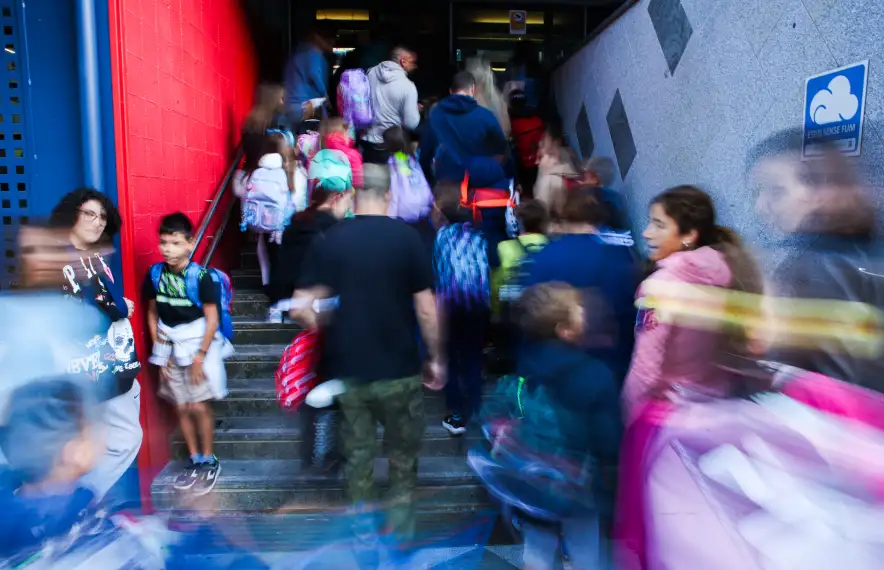 Alumnes i pares el primer dia de curs a la porta d'una escola.
