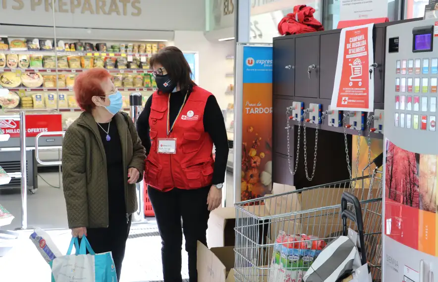 Una voluntària de la Creu Roja Andorrana amb una de les persones que ha donat una bossa d'aliments en una recapte anterior.