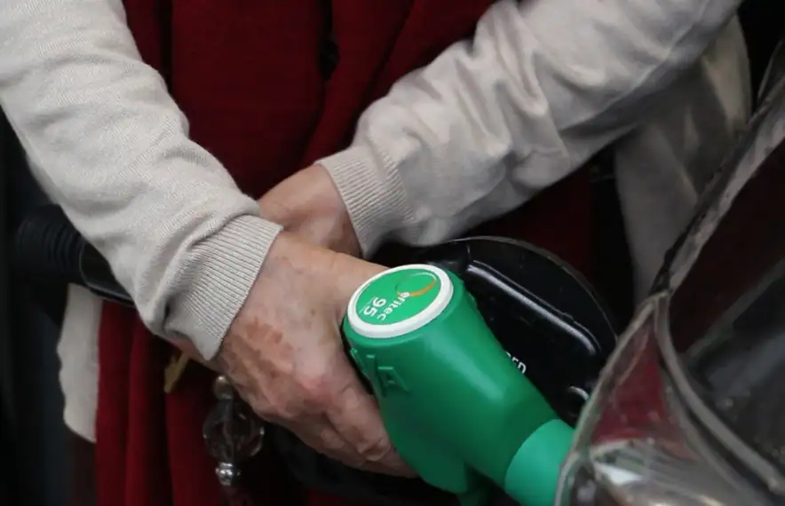 Un client se subministra carburant en una estació de servei.