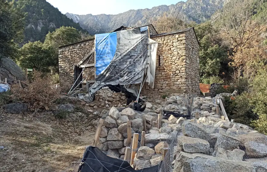 Aspecte actual de Sant Vicenç d’Enclar, amb el forat del campanar cobert per una lona, i les pedres apilades i ordenades.