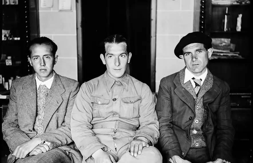 Al mig, un militar republicà que s’ha arrencat prudentment els galions de la jaqueta. Amb el seus companys, posa a l'interior de la farmàcia Areny-Plandolit, als baixos de la casa Guillemó.