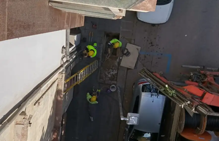 Vista dels operaris de Peusa treballant per impedir l’accés fraudulent al subministrament, des d’un dels pisos ocupats.