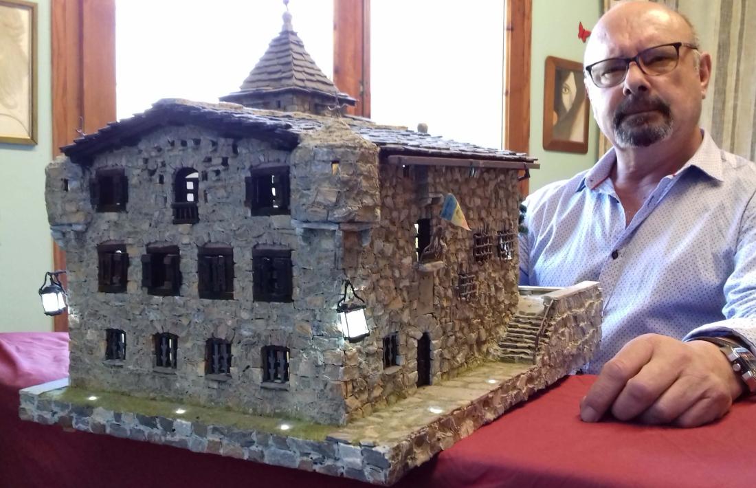 Joaquim Bessa Macedo, al seu pis-taller de la capital, amb la maqueta de Casa de la Vall, l'última que ha construït, d'un detallisme extrem que inclou estripagecs, porticons, escut, bandera i rodes de molí.