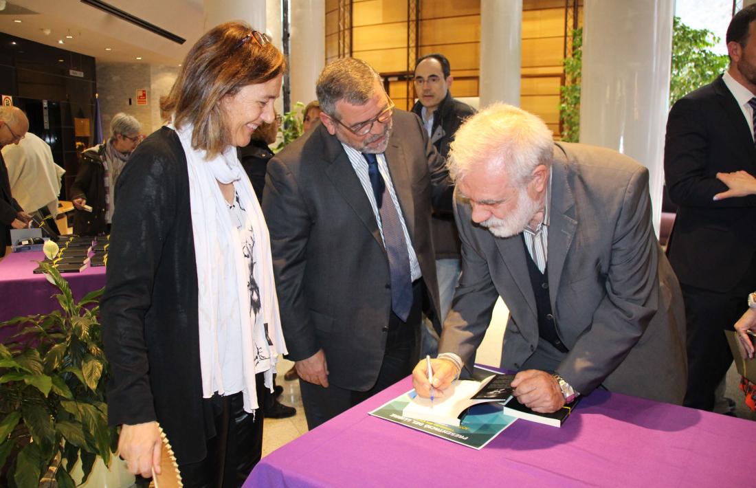 Dalleres firma un exemplar del llibre davant de la cònsol menor, Ester París, i el president del consell d'administració de la CASS, Jean Michel Rascagneres.