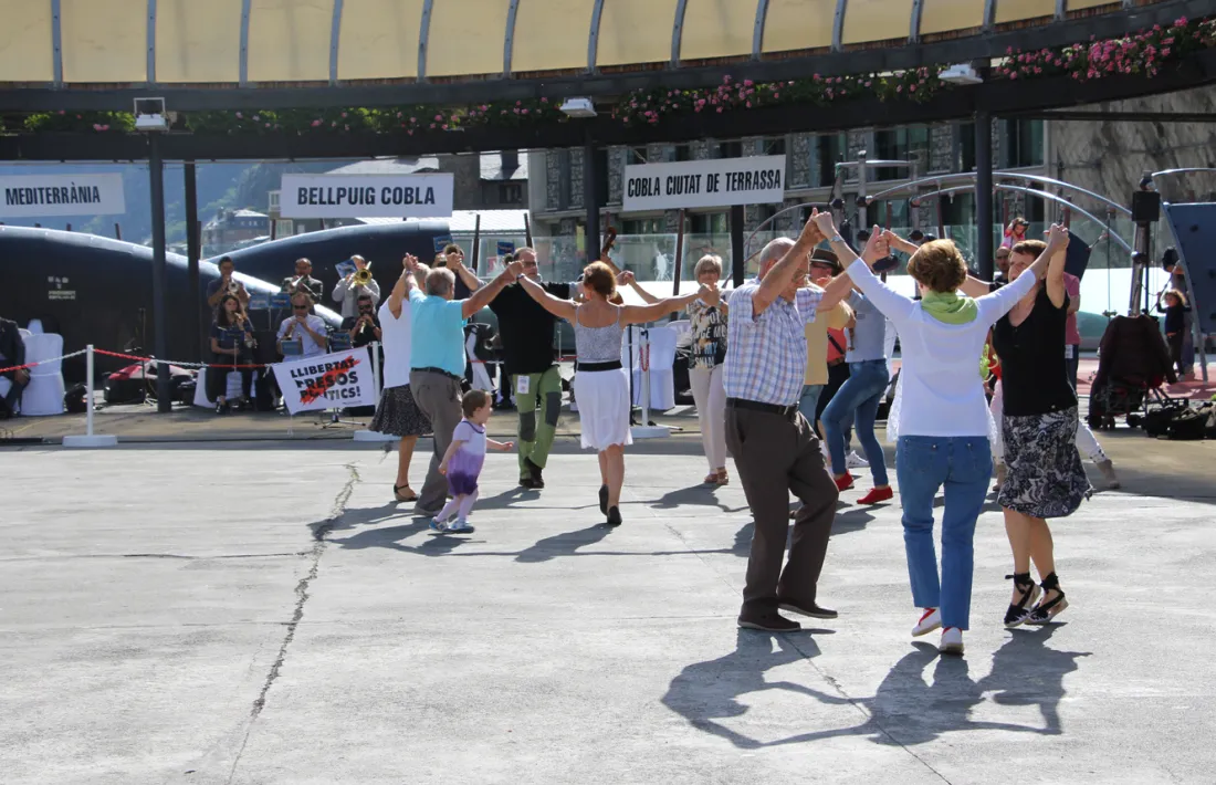 La cobla Bellpuig, al fons, amb la pancarta a favor dels ‘presos polítics’ catalans.