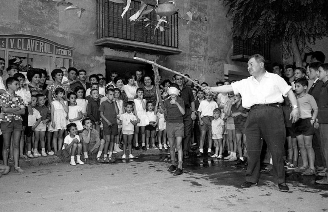 Jocs de cucanya a la plaça Benlloch, just al davant de la botiga Claverol, a la festa major de 1962.
