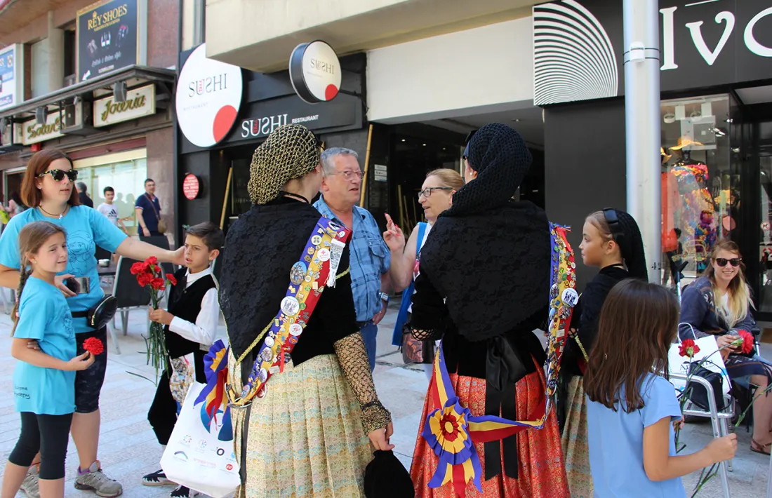 Turistes conversen amb la pubilla i la dama de la parròquia.