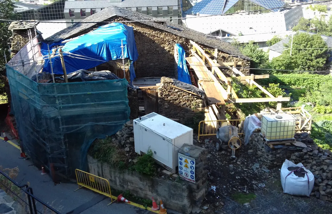 Vista de cal Ribot, amb l'era en primer terme: a la dreta, el mur i el llosat del paller, totalment retirats; a l'esquerra, la xemeneia i el que queda del mur de la cort.