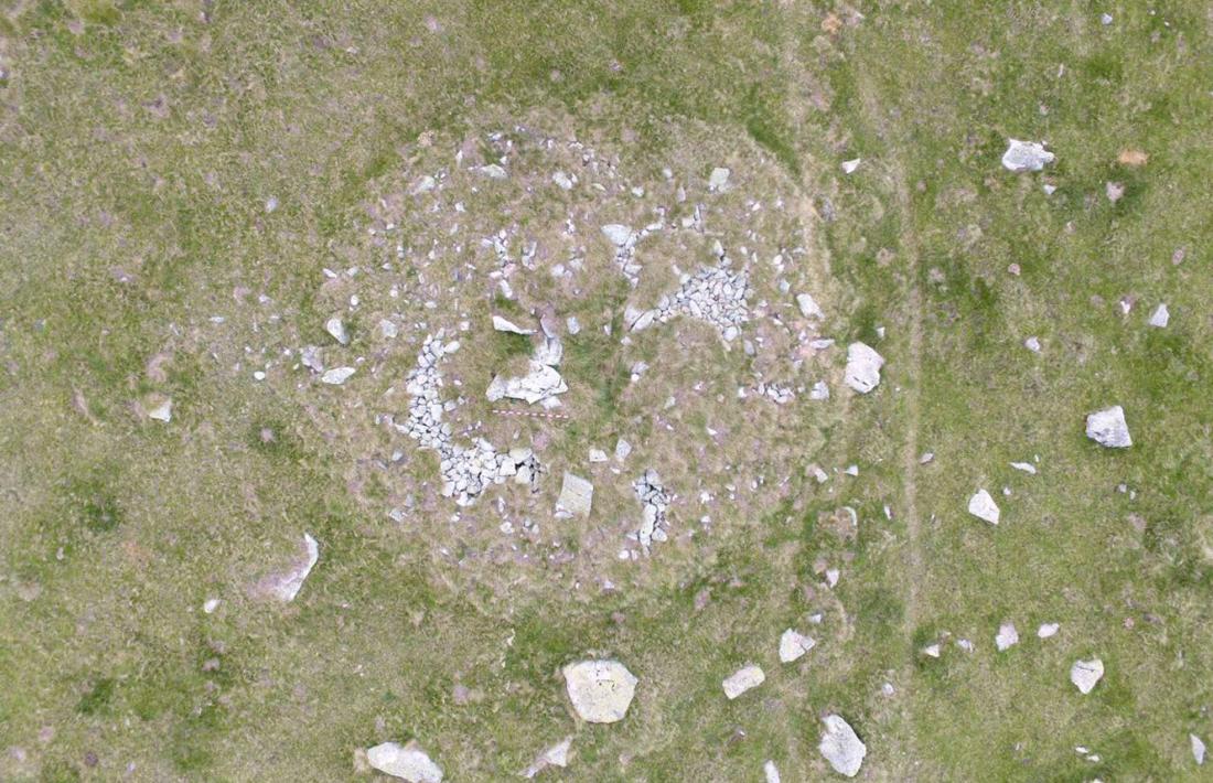 Vista aèria del dolmen d’Encenrera: les lloses de la cambra mortuòria, al centre del túmul, són quasi tan llargues com el pal, que fa dos metres.