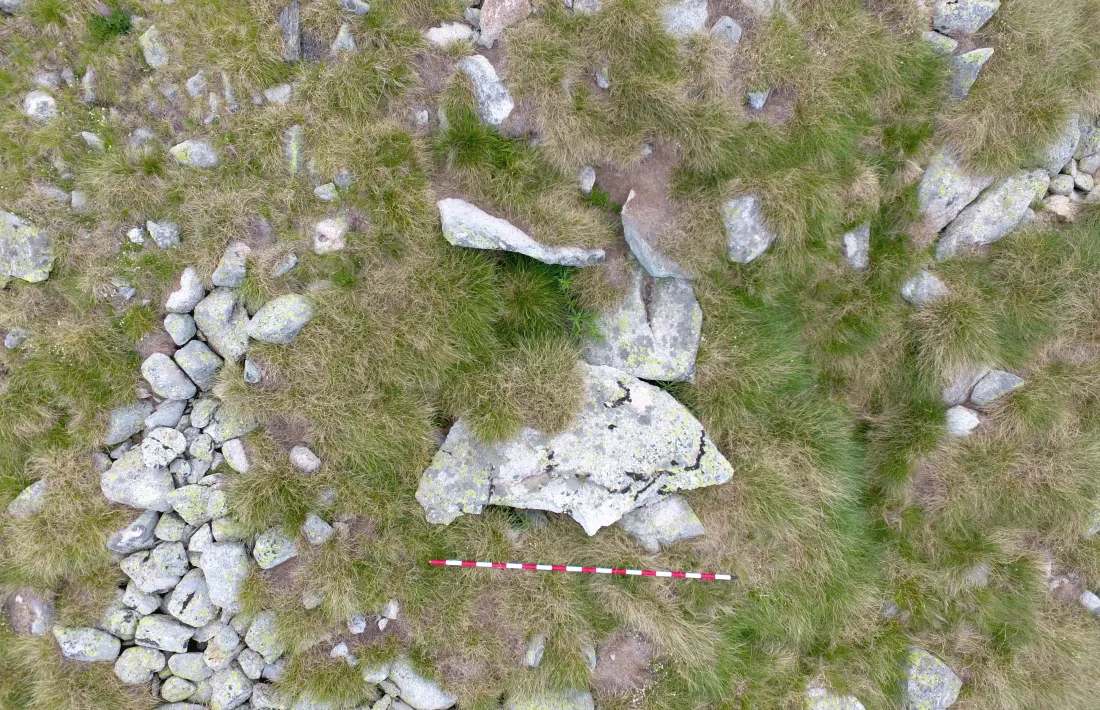 Perspectiva zenital del dolmen d’Encenrera, amb les lloses de la cambra i el cercle del cromlec clarament marcat: el pal fa dos metres.