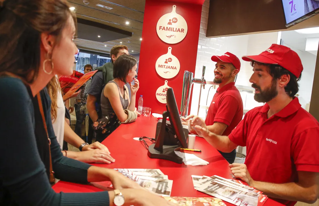 Clients fent comandes al nou local de Telepizza a Andorra.