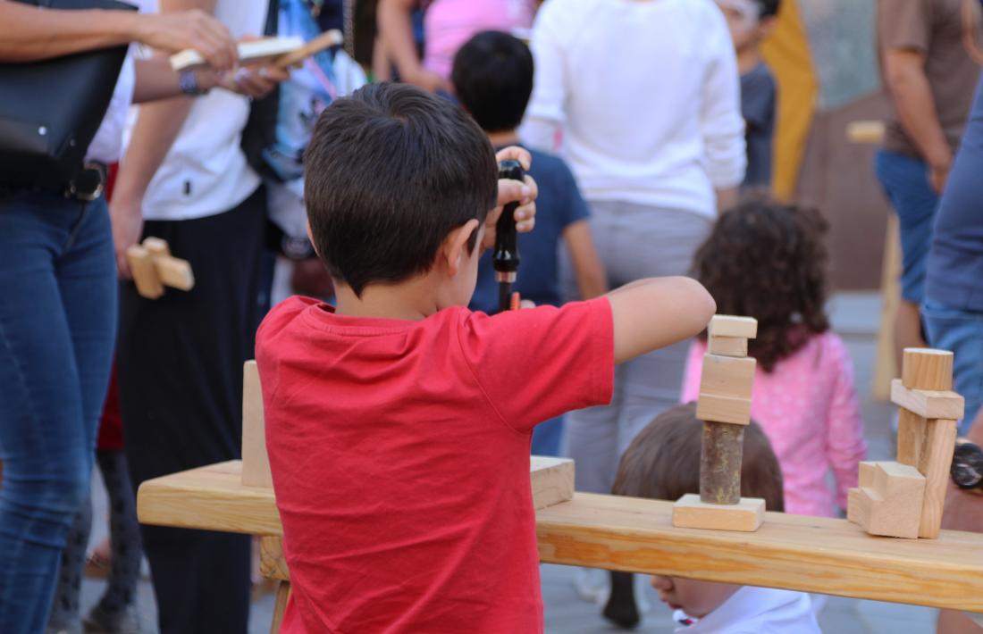 Un infant durant el taller de fusta de la Vila Medieval.