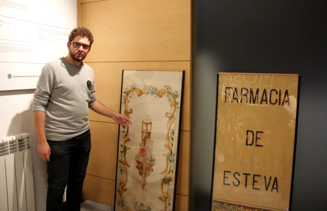 El director del Museu de Llívia, Gerard Cunill, mostrant les teles de l’antiga Farmàcia Esteva.