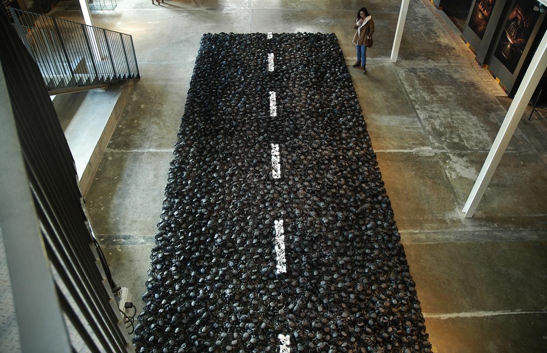 La carretera fa 20 metres de llarg per 4 d’ample, i està formada per 3.000 crancs, modelats a mà i un a un; Balmaseda hi ha dedicat un any de feina; a dalt, la instal·lació, al Terracotta Museu; a baix, fa dos anys, amb les primeres proves al seu taller de la capital.