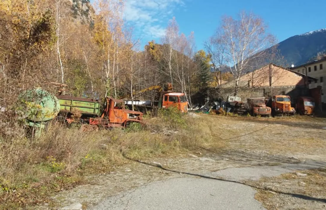 Solar de Santa Coloma amb els vehicles estacionats: hi ha un GMC, un Ford, una grua Fiat, un Renault i un Hemshel alemany.