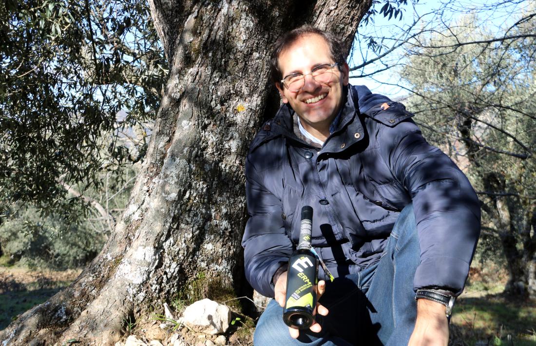 Ivan Caelles, productor de l’oli Erm, mostra una ampolla als peus d’un oliver.