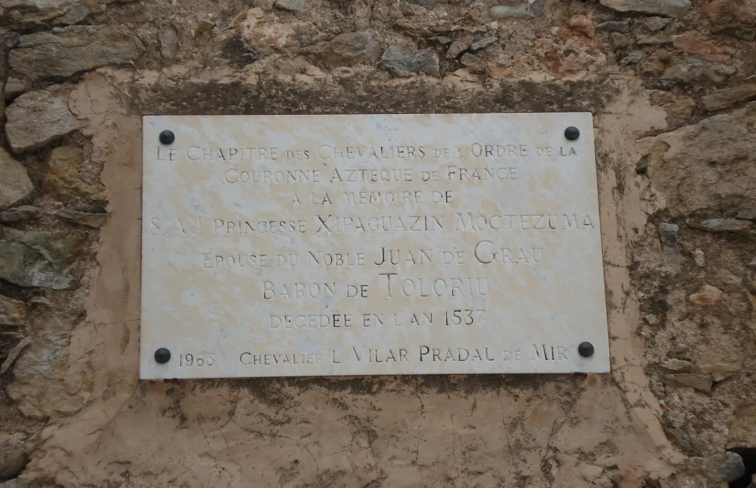 La casa Vima, als afores de Toloriu, on diu la llegenda que Maria es va establir; a baix, placa apòcrifa en memòria de la princesa Xipaguazin Moctezuma.