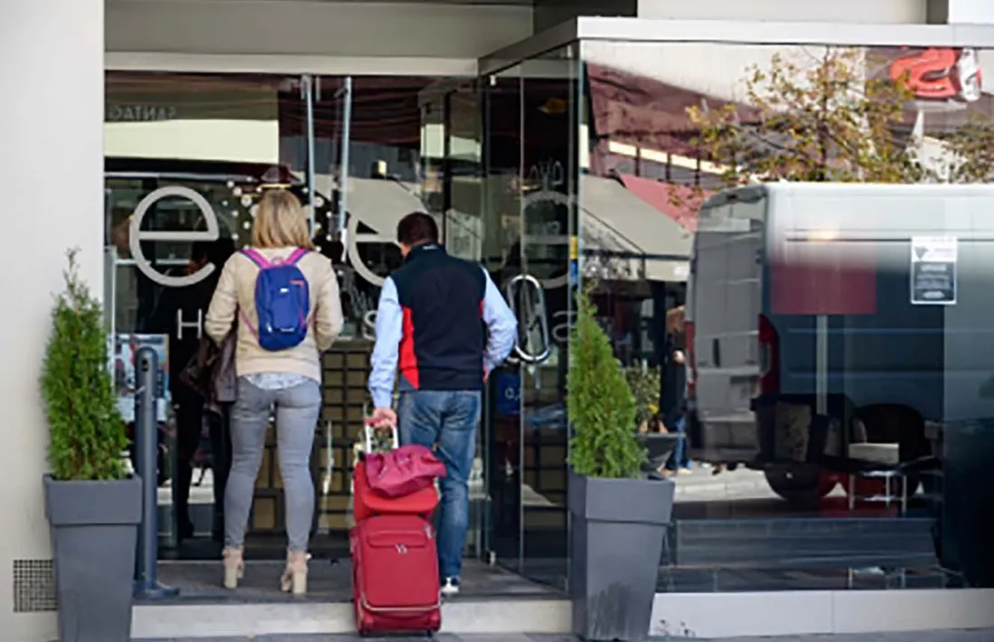 Dos turistes entren a un hotel.