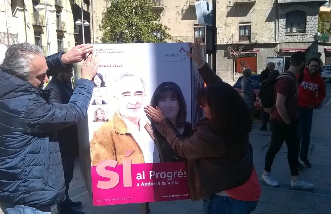 Àngel Dalmau i Meritxell Pujol enganxant el cartell de la territorial de Progressistes-SDP a la capital.