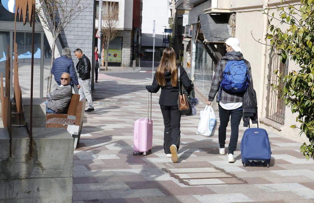 Dos turistes amb maletes pel centre d’Escaldes-Engordany.