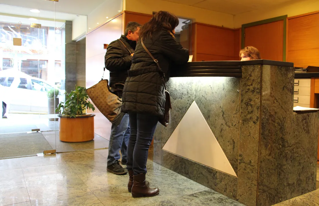 Turistes a la recepció d'un hotel.