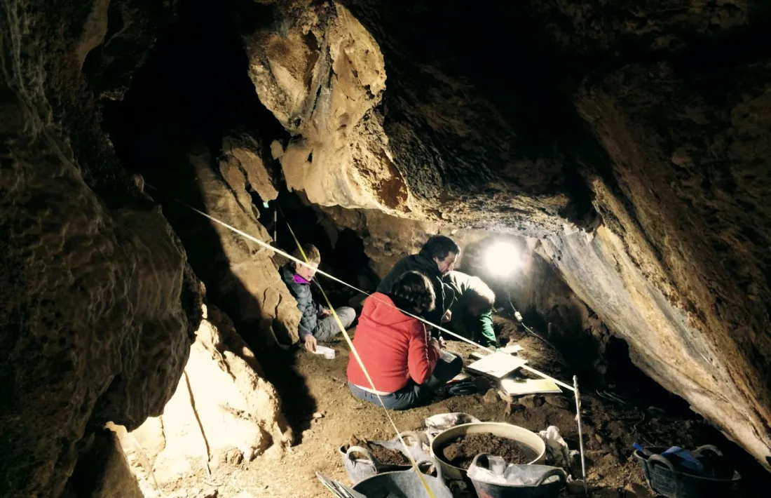 Restes d’un individu i una eina trobades a l’interior de la Cova de l’Home Mort.
