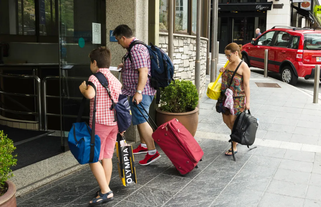 Turistes al davant d'un hotel.