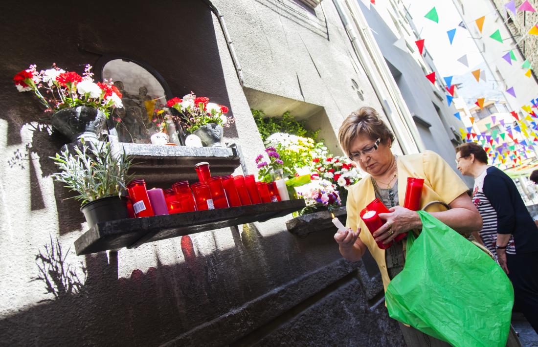 Una veïna encèn una espelma a l’oratori de Sant Antoni, al Puial.