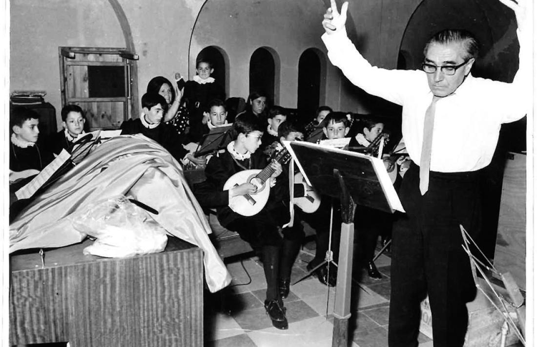 El mestre Joan Serra, que exercia com a professor a l’escola espanyola, dirigeix un assaig de la tuna a Sant Esteve; entre els tuners hi ha els germans Jordi i Josep Maria Tejero, Virgili Tomàs, Enric Bartumeu, Joan lladós i Toni Portell, entre d’altres.