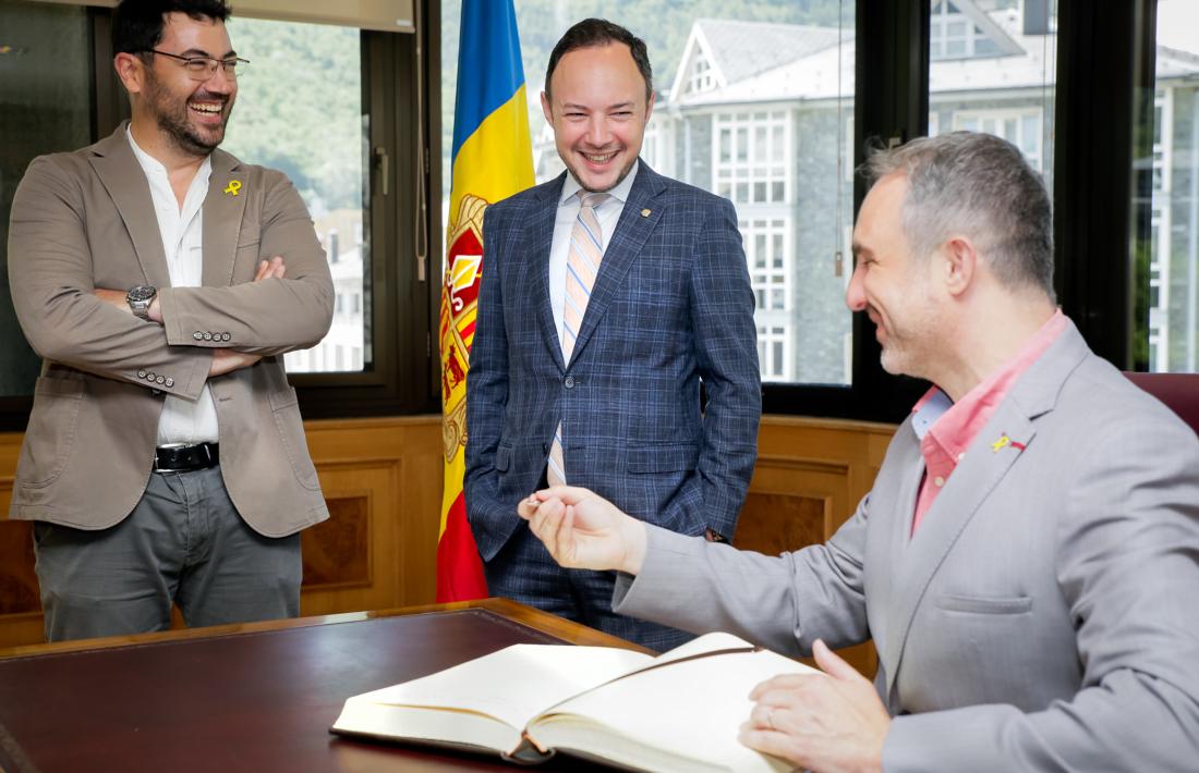 L'alcalde de la Seu d'Urgell, Jordi Fàbrega, firma el llibre d'honor amb presència del cap de Govern, Xavier Espot, i del regidor de l'ajuntament Francesc Viaplana.