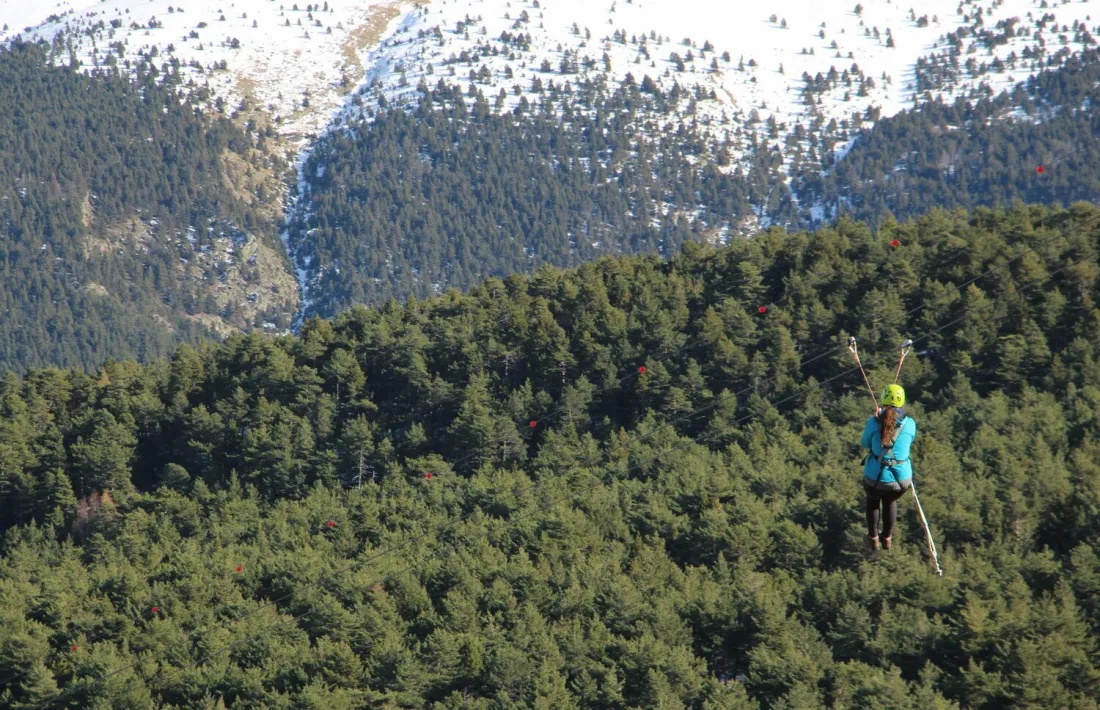 Una noia es llença per la tirolina que hi ha actualment a Naturlàndia, a la cota 1.600.