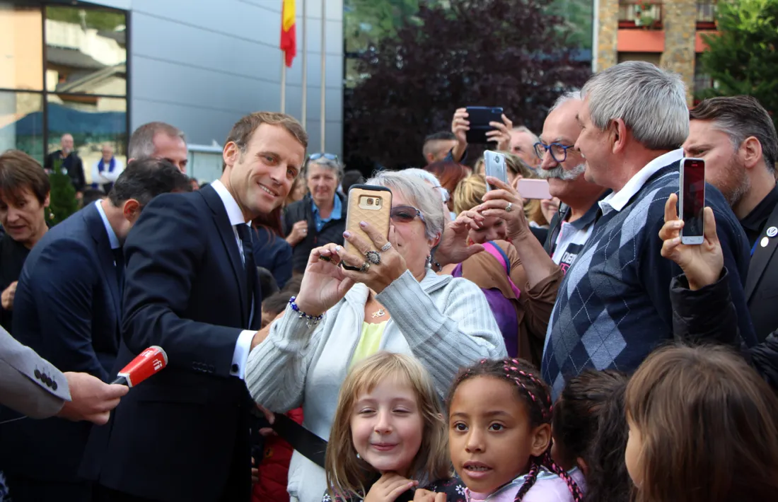 El copríncep francès va accedir a fer-se una selfie amb una encampadana, en la visita de divendres a la parròquia.