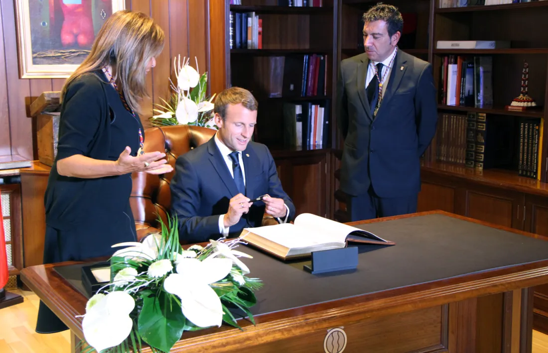 El copríncep Macron firma el llibre d'or de la capital.