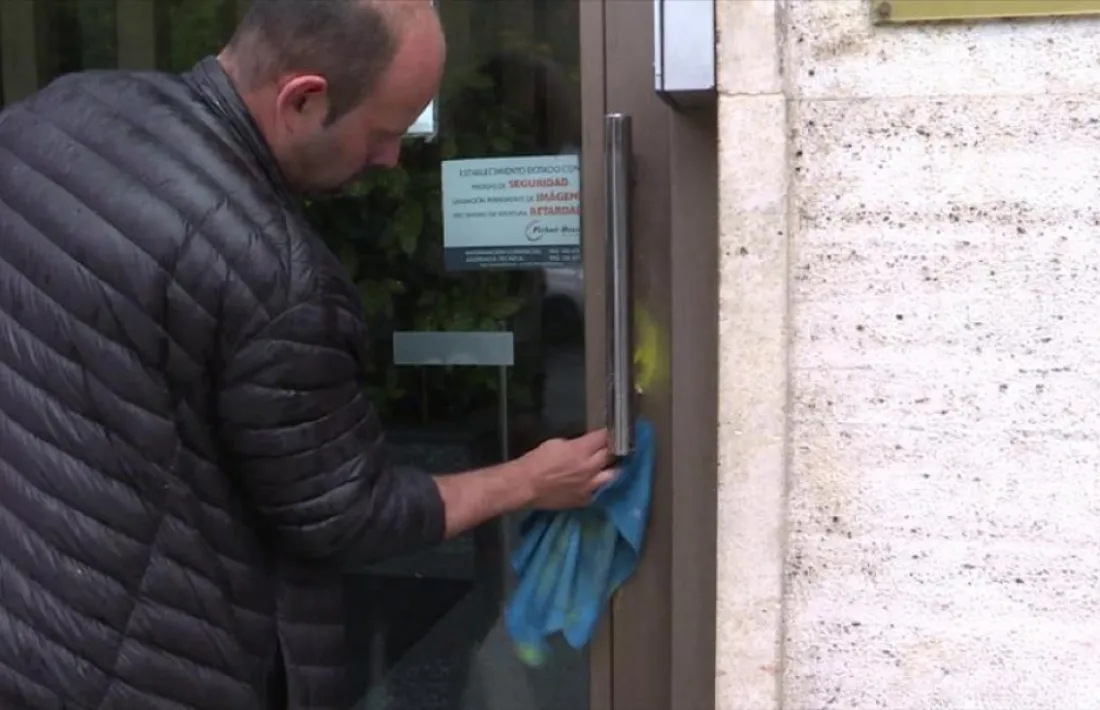 Un operari acabant d’esborrar ahir al matí les restes de les pintades a la façana.