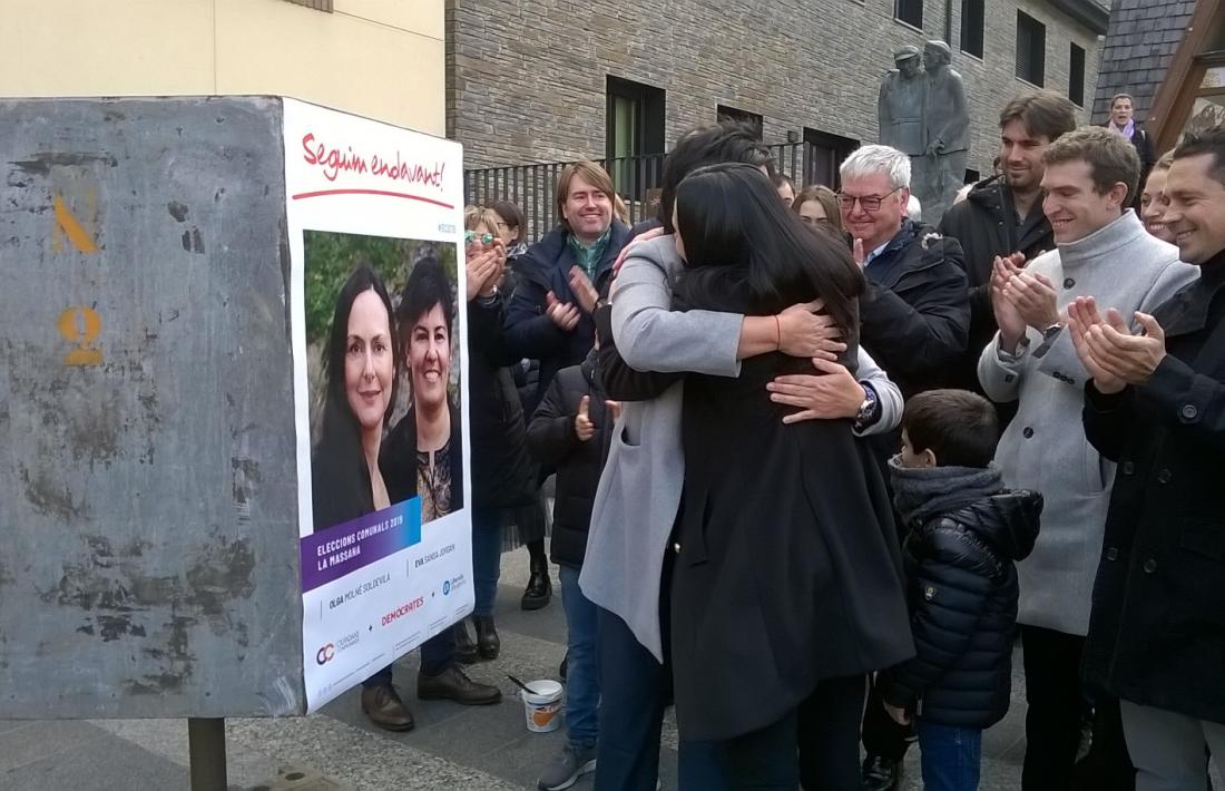 Olga Molné i Eva Sansa s’abracen després de penjar el primer cartell i donar el tret d’inici a la campanya d’uns comicis “una mica especials”.