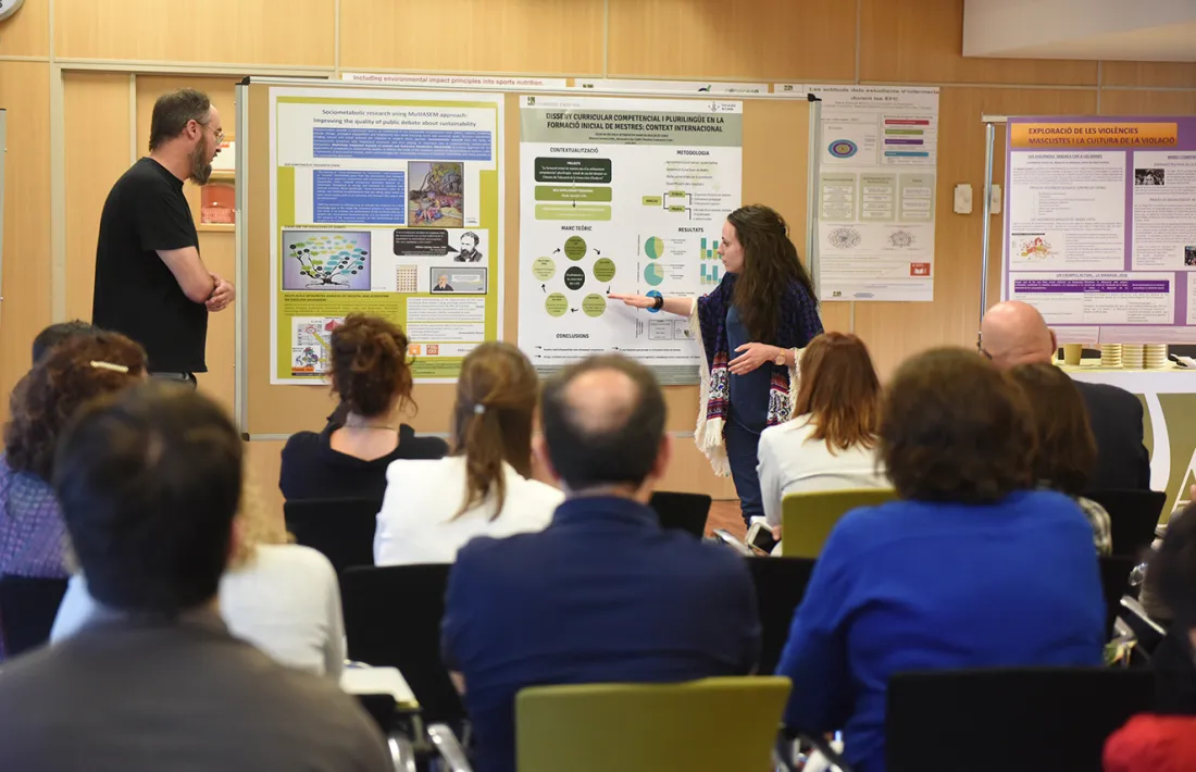Una doctoranda exposa el pòster de la tesi doctoral durant el Seminari de recerca.