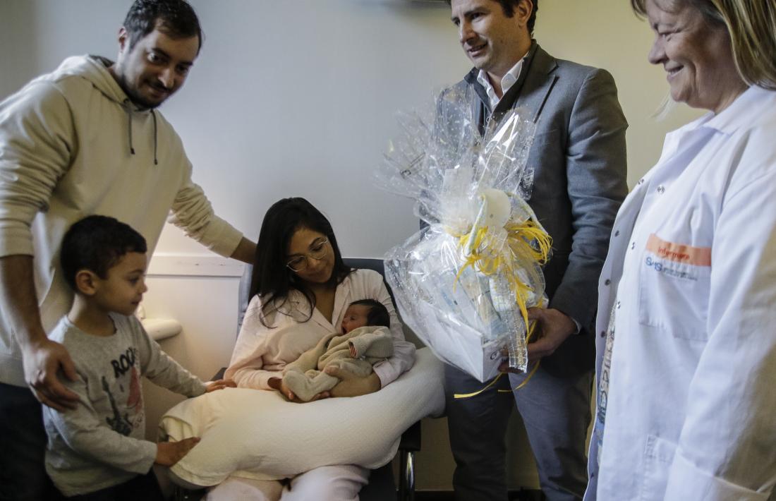Moment en què personal del SAAS lliura una cistella a la família del primer nadó de l’any, ahir al matí.