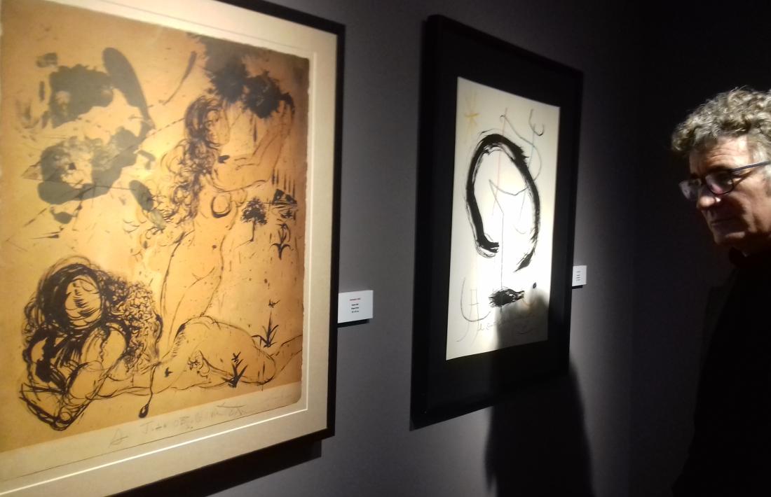 Jordi Obiols contempla un dibuix de MIró i un altre de Dalí, dues de les obres que s'exposen al Museu Fàbrica Reig.