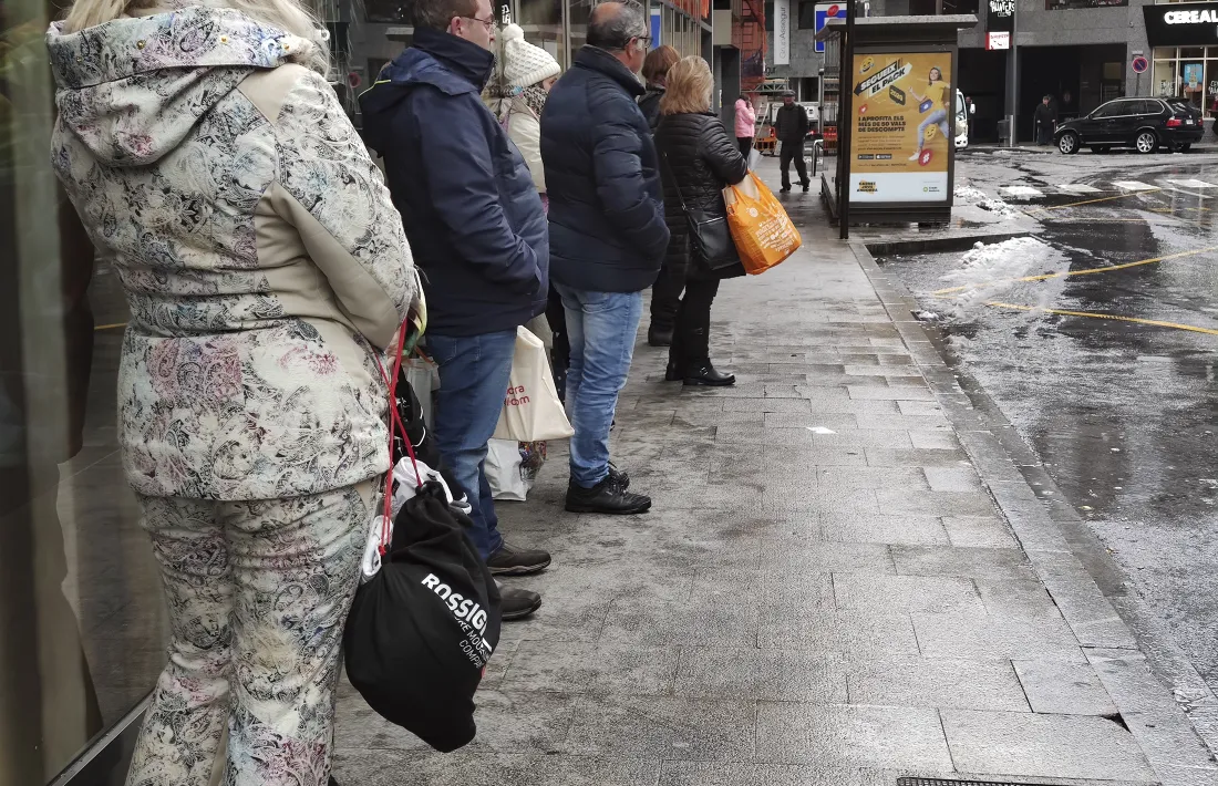 Usuaris del transport públic, entre els quals esquiadors, esperant l’arribada de l’autobús.