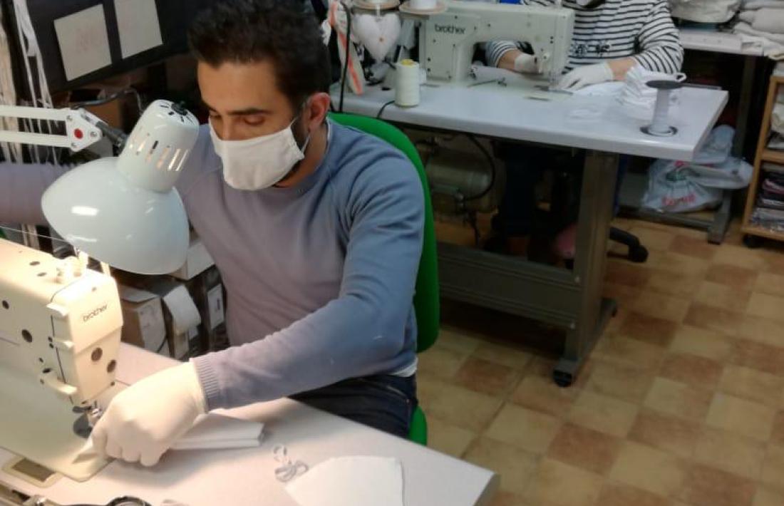 Dos voluntaris concentrats en la confecció de mascaretes a Sant Julià. 