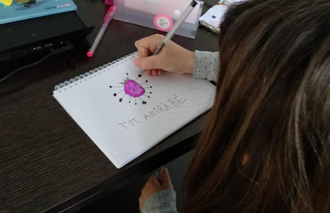 La Joana dibuixa un coronavirus coronat amb el lema 'Tot sortirà né'.