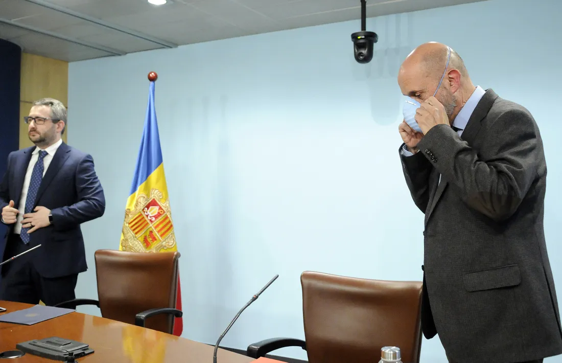 El ministre de Salut, a la dreta, es treu la mascareta abans de la compareixença d'aquesta tarda.