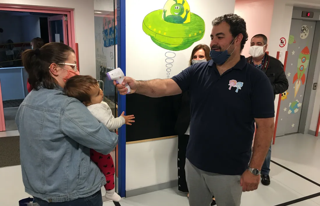 El director de l'escola bressol pren la temperatura a un infant.