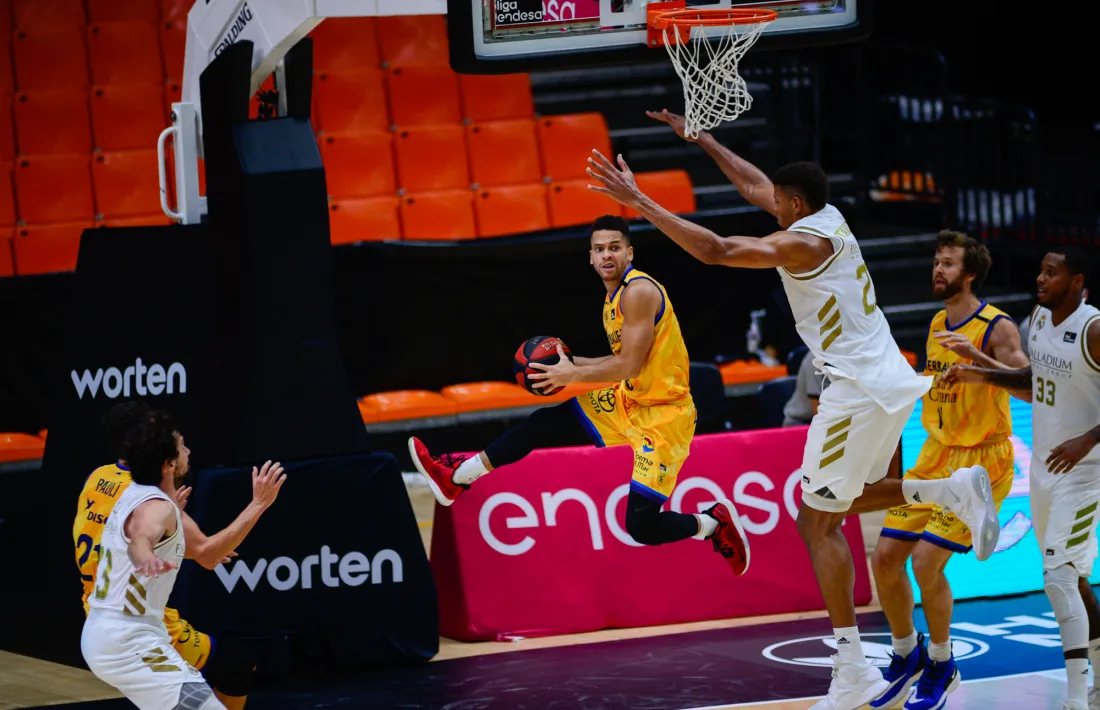 El menut base belga de l’Herbalife Gran Canària, Manu Lecomte, intenta una entrada intimidat pel gegant Edy Tavares.