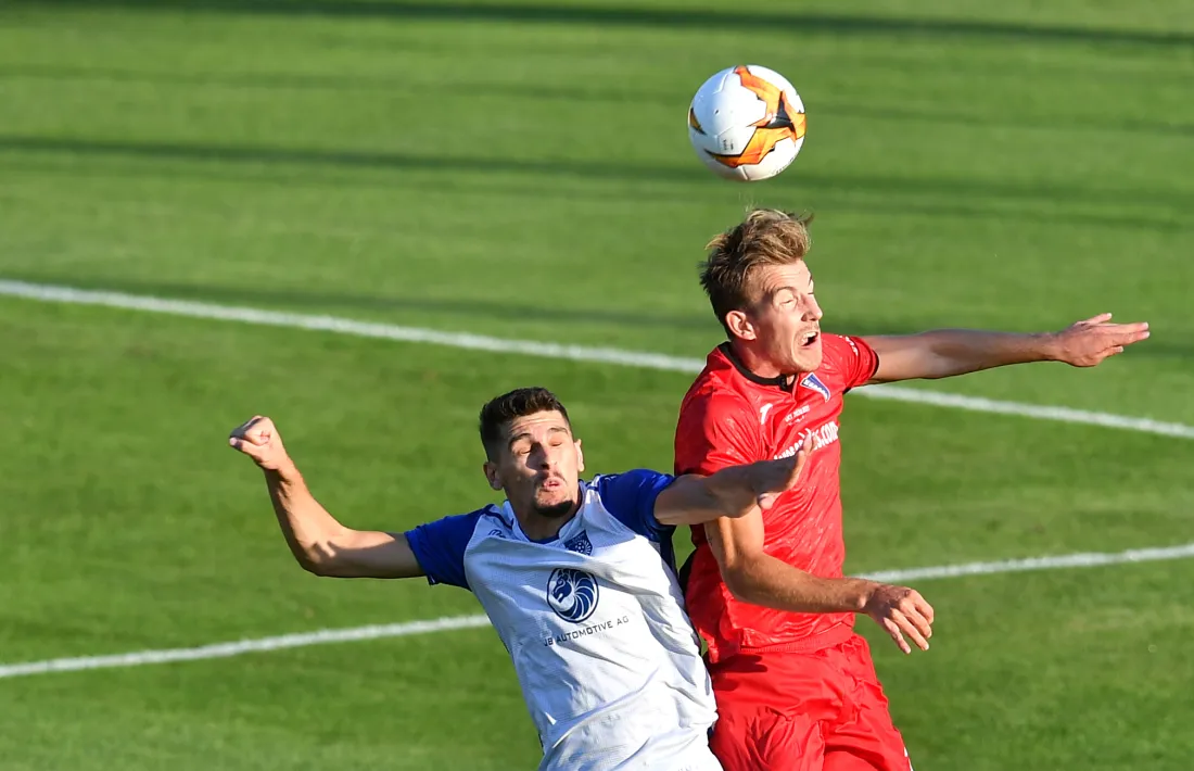  El defensa central de l’Inter Club Escaldes, Raul Feher, lluitant per una pilota àeria amb un jugador del Drita