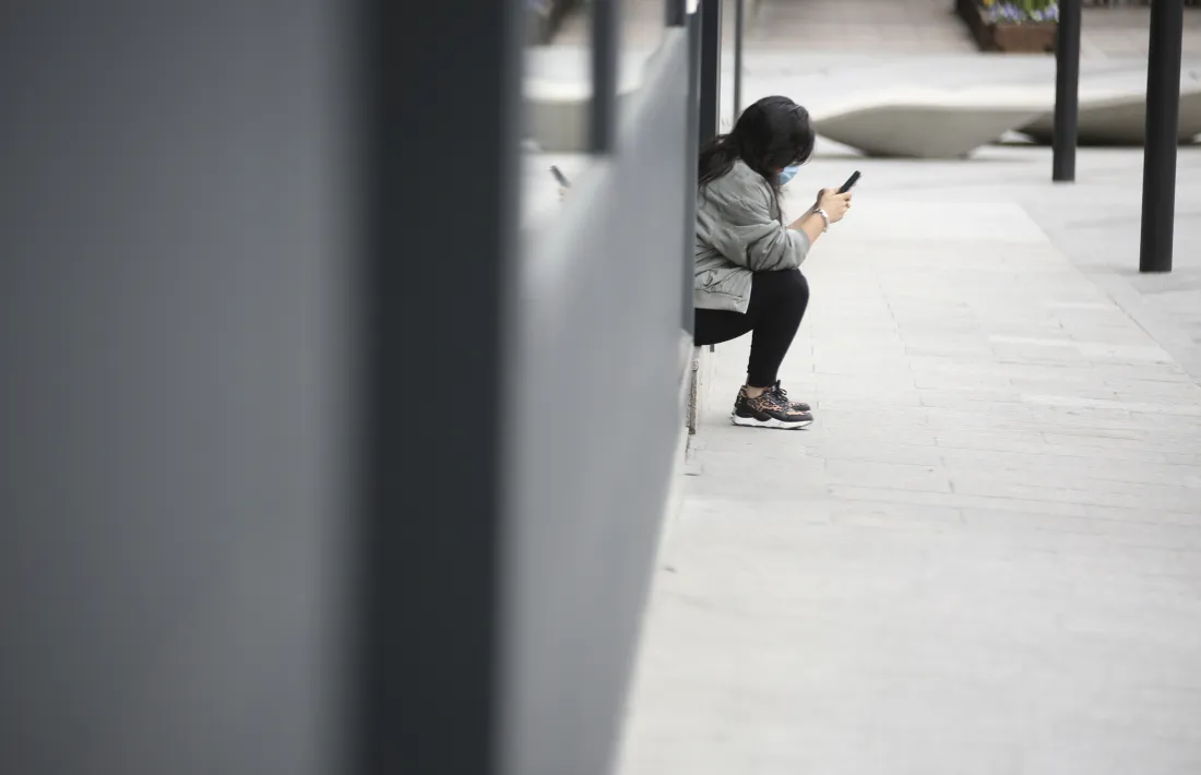 Una persona utilitzant el seu telèfon mòbil.