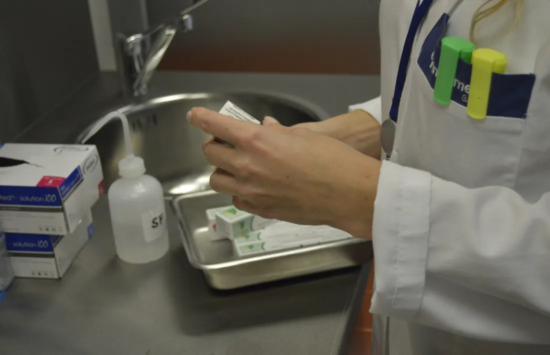 Un professional mèdic prepara medicaments abans d’atendre un pacient.