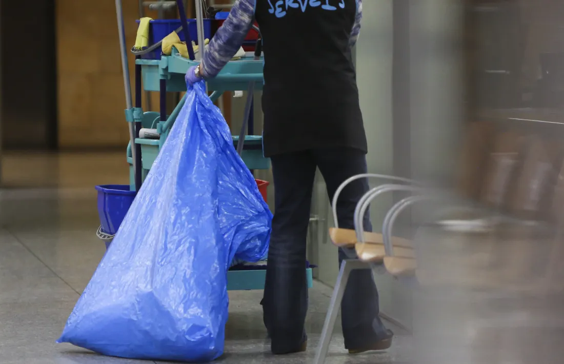 Una dona realitzant tasques de neteja al seu lloc de treball.